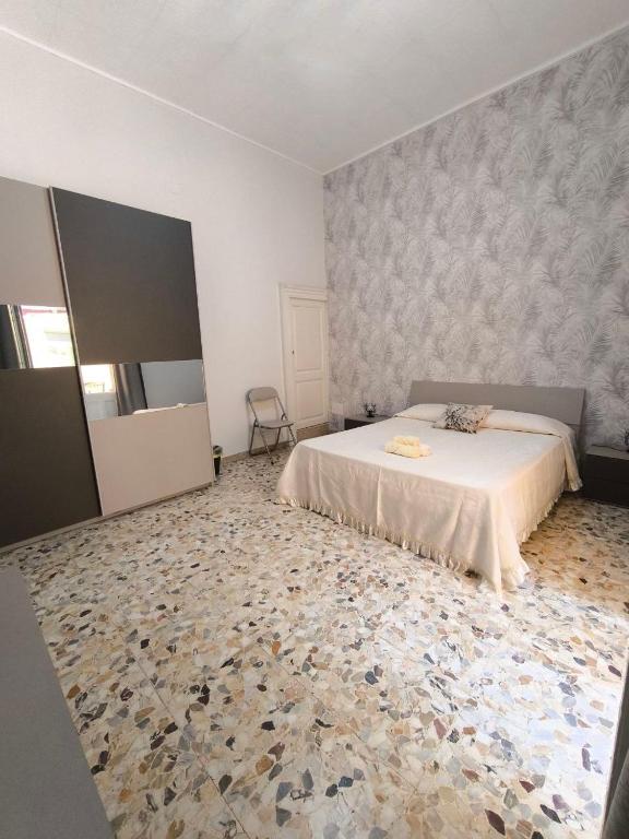 a bedroom with a white bed and a carpet at la casa del viaggiatore in Bronte