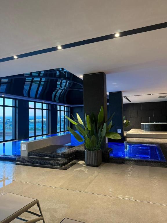 a building with a pool with a plant in the middle at Baltic Infinity Beach Spa in Międzyzdroje