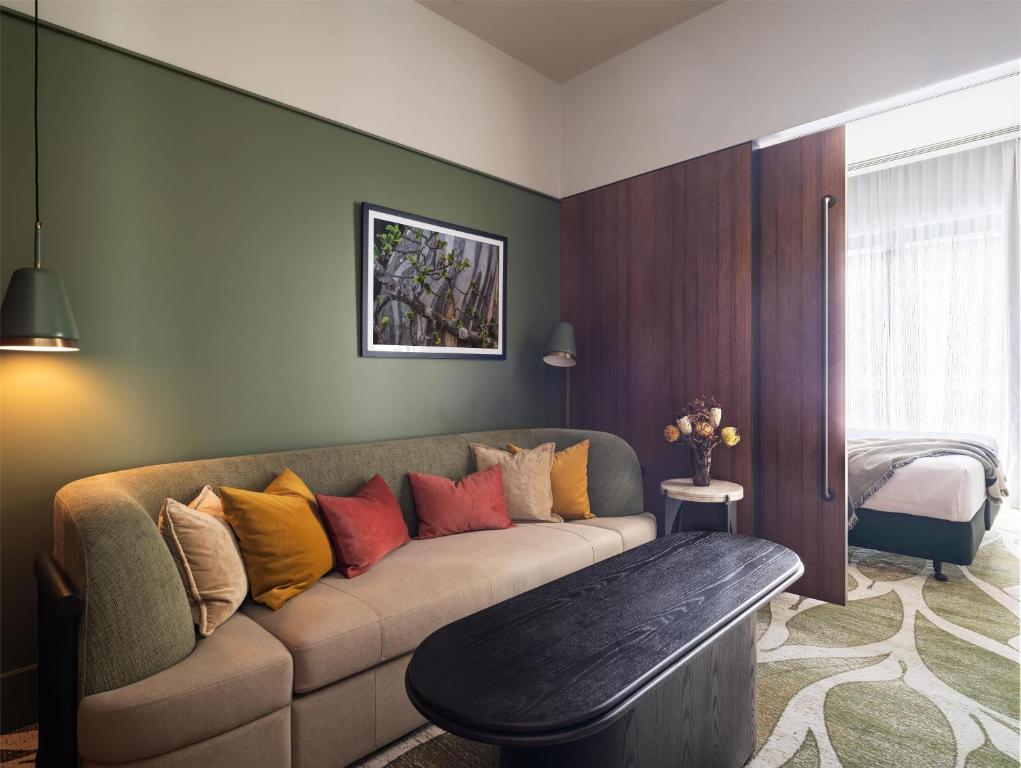 a living room with a couch with colorful pillows at Adina Hobart in Hobart