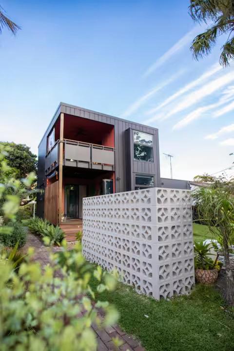 a house with a white fence in front of it at The Royale Bundeena in Bundeena