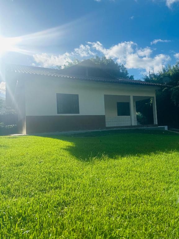 a house with a green lawn in front of it at Casa do Carol Sana in Macaé