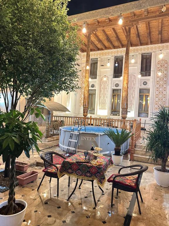 a patio with a table and chairs in front of a building at OROM PONORAMA VIEW old city in Bukhara