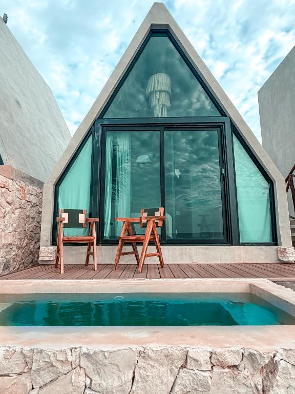 a glass house with a table and chairs on a deck at Danselis Boutique Hotels in Telchac Puerto