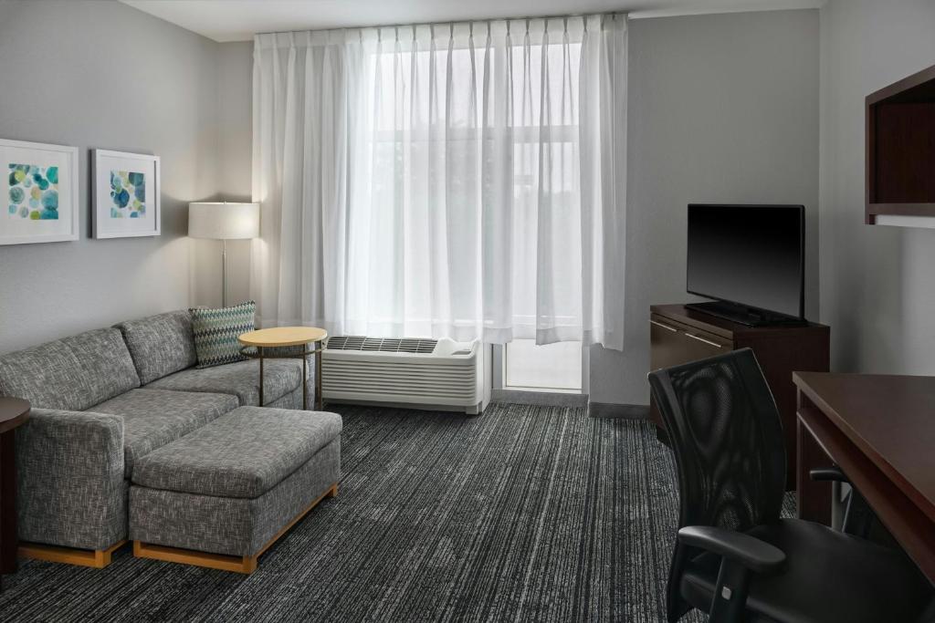 a living room with a couch and a tv in a hotel room at TownePlace Suites by Marriott Springfield in Springfield