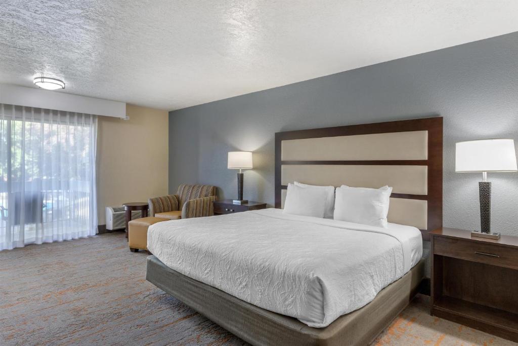 a hotel room with a bed and a chair at Best Western Sunridge Inn & Conference Center in Baker City
