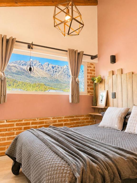 a bedroom with a large bed with a mountain view at Cabañas Sublime Bolson in El Bolsón