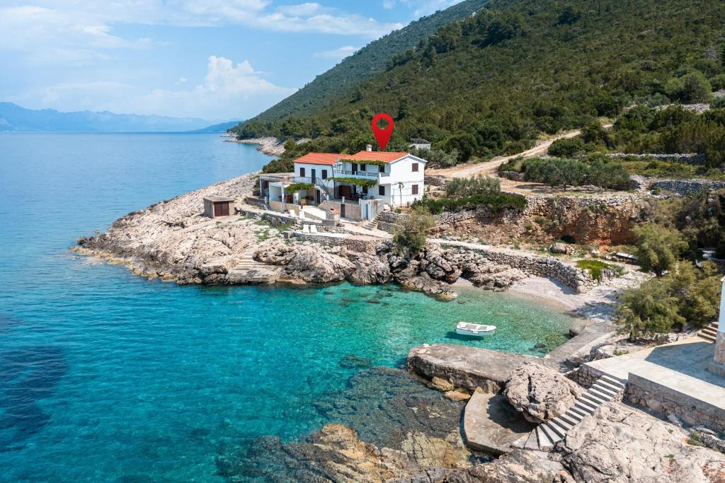 a house on a rocky island in the water at Seaside secluded apartments Cove Virak, Hvar - 12321 in Gdinj
