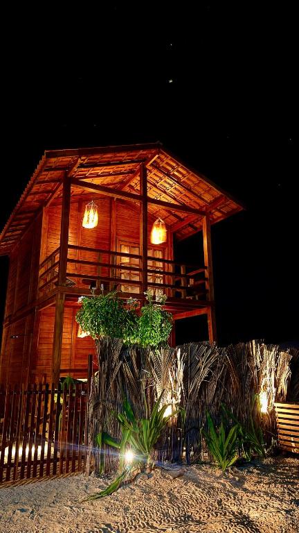 a large wooden building with lights on it at night at VENTO A GOSTO Chalet - Atins in Atins