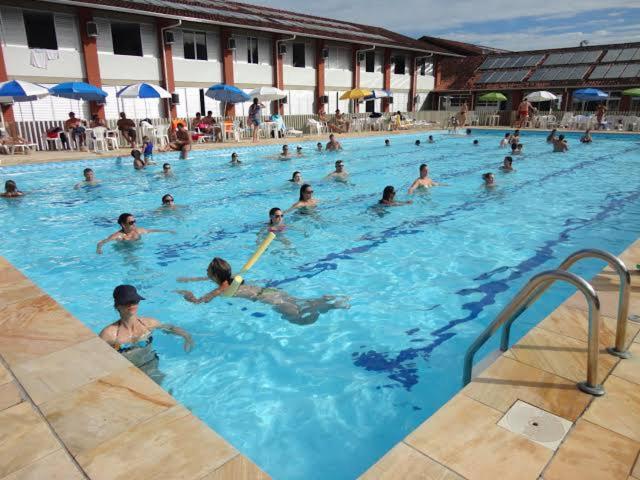 a group of people swimming in a swimming pool at Pousada Fecep in Guaratuba