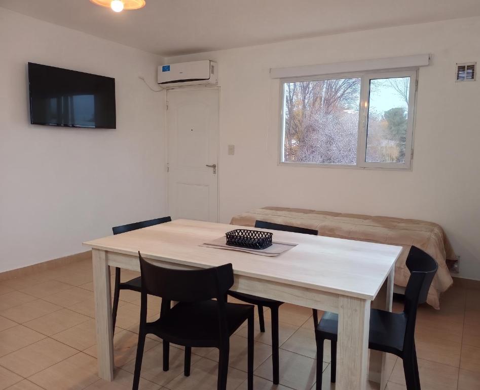 a table and chairs in a room with a couch at Complejo Los Arrayanes - Plottier in Plottier