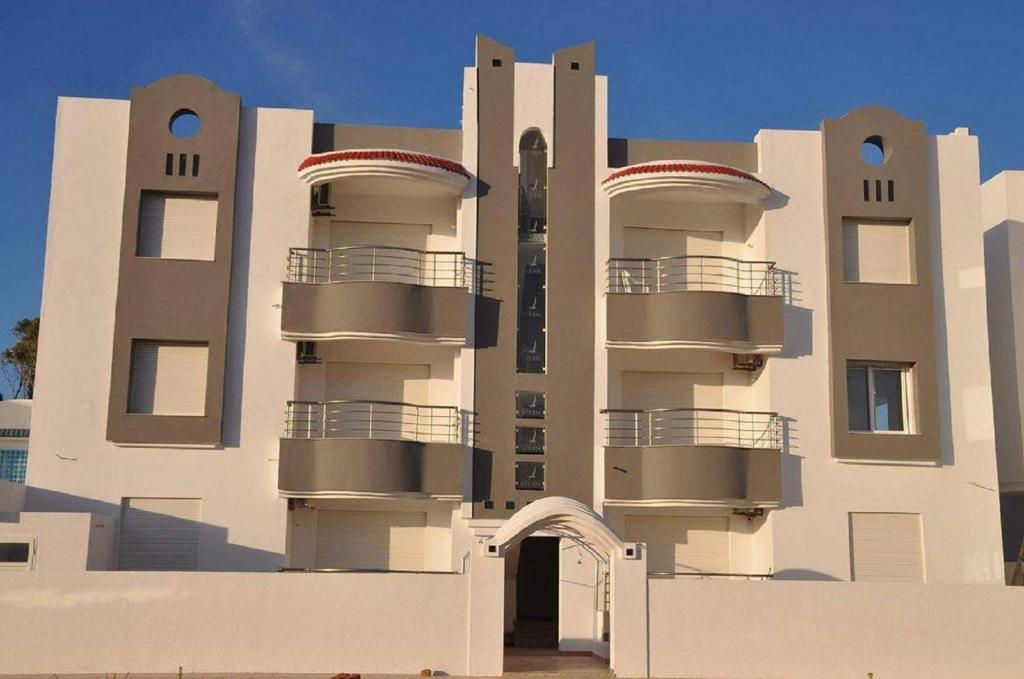 - un bâtiment avec des balcons sur le côté dans l'établissement Residence Sterne, à Ḩammām al Ghazzāz