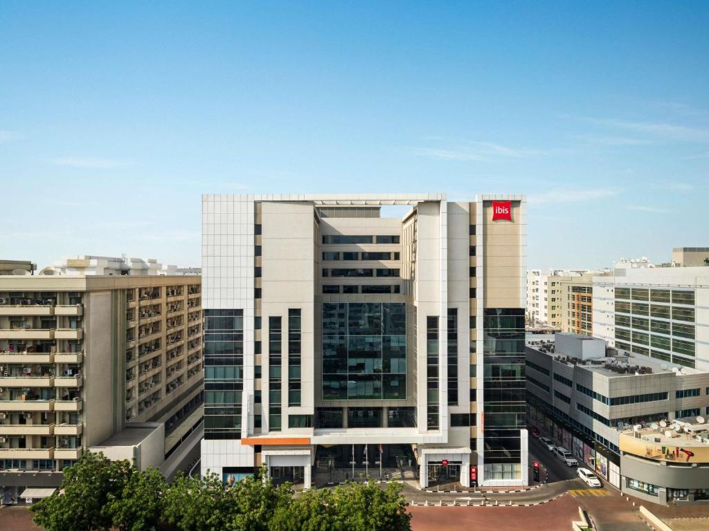 a tall white building with a chinese flag on it at ibis Dubai Al Rigga in Dubai