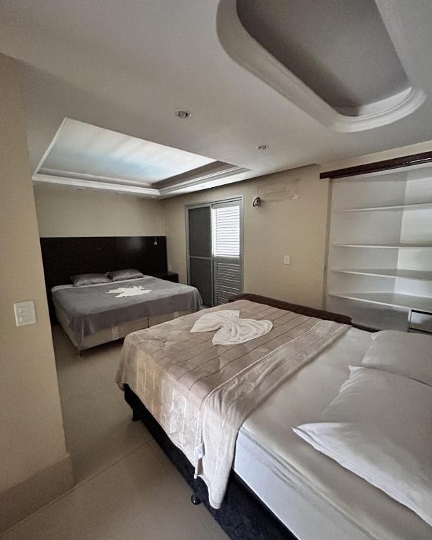 a bedroom with two beds and a skylight at Pousada Recanto do Bosque in Luziânia