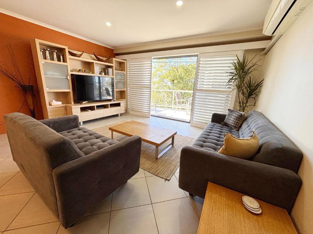 a living room with two couches and a tv at Jubilee Apartment 14 in South West Rocks