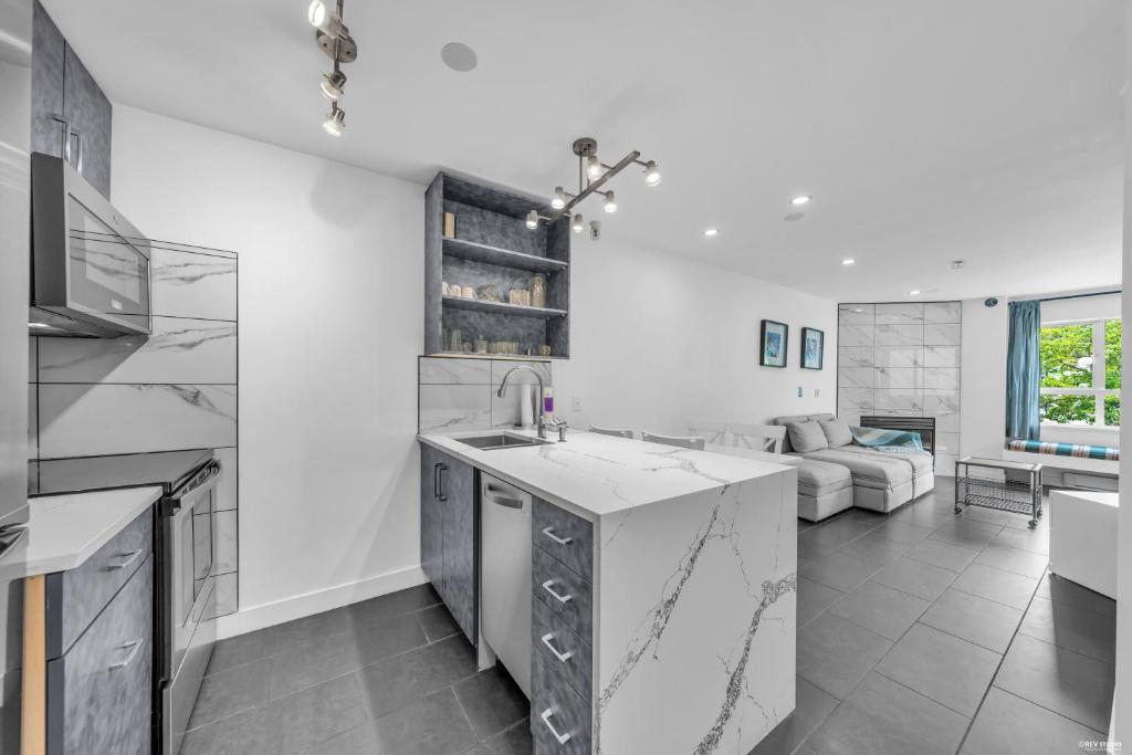 a kitchen and living room with a couch at Central Alpine Condo in Whistler