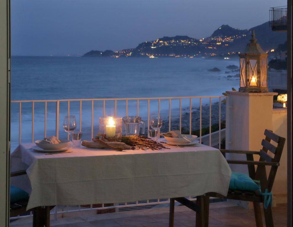 a table on a balcony with a view of the ocean at Taormina Holidays Residence in Forza dʼAgro