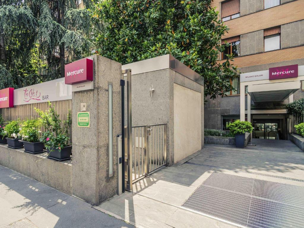 a gate in front of a building with plants at Hotel Mercure Milano Solari in Milan