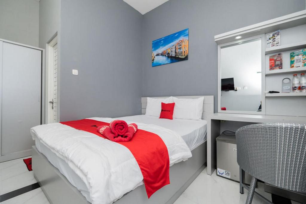 a bedroom with a bed with a red rose on it at RedDoorz Plus near Politeknik Negeri Malang in Malang