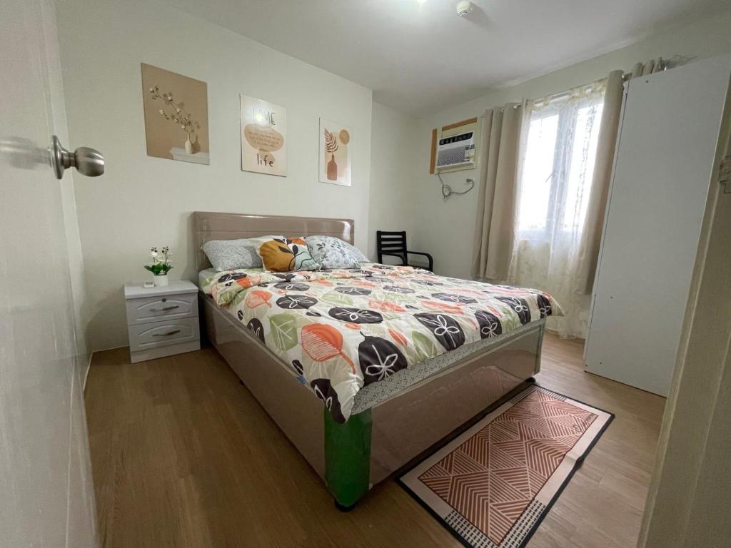 a bedroom with a bed with a comforter and a window at Nier Haven at The Loop North Tower in Pontud