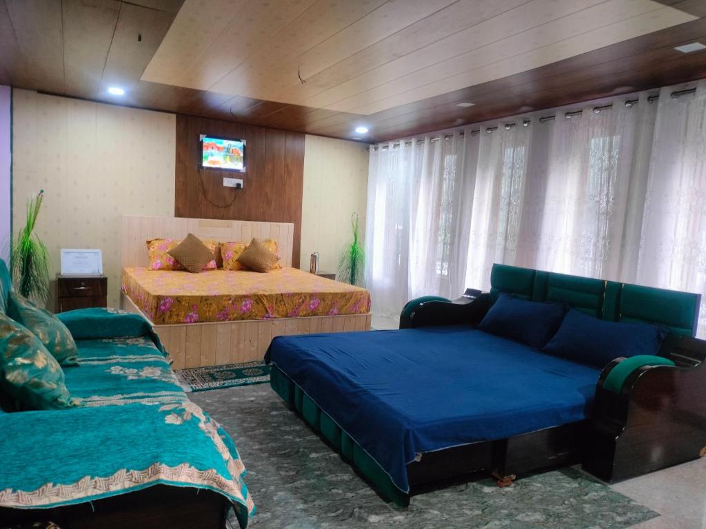 a bedroom with two beds and a couch and a tv at Rautelahomestay in Harsil