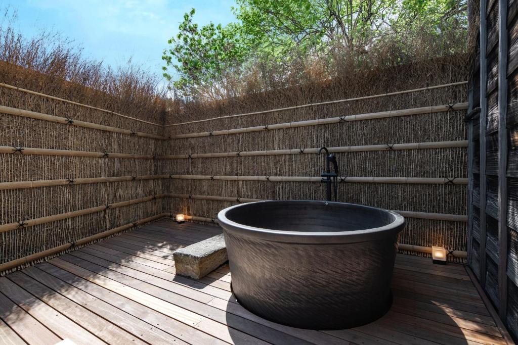 a bath tub on a deck with a wooden fence at 一乗谷 朔 saku in Fukui
