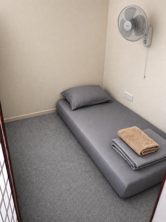 a bed in a room with a fan at The Plywood Pod in Rawalpindi