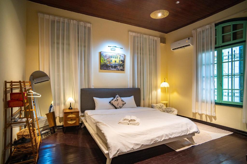 a bedroom with a large bed with white sheets at DoDo Apartments in Hanoi