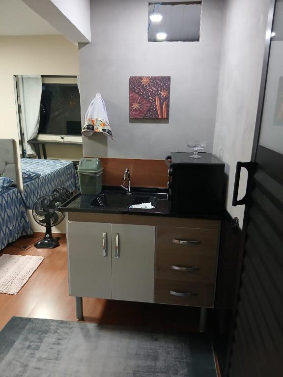 a room with a sink and a bedroom with a bed at Loft Meu Aconchego in Nova Friburgo