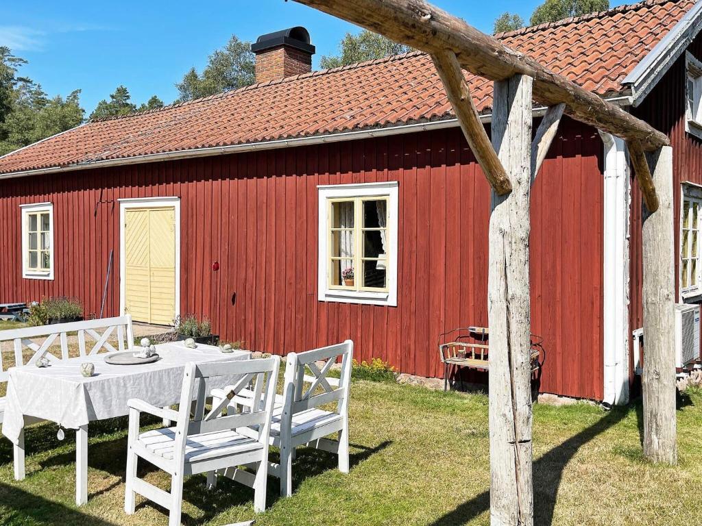 a table and chairs in front of a red building at 4 person holiday home in Furuby in Furuby