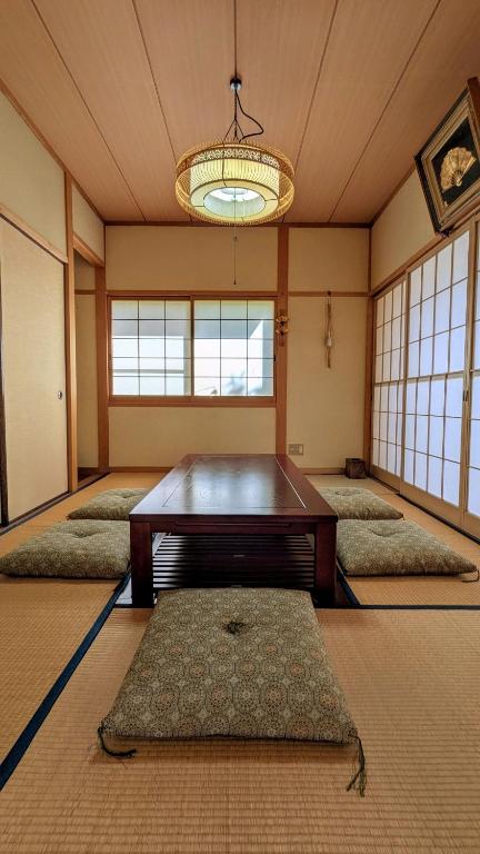 a room with a table in the middle of a room at ゲストハウスヒスイ in Kuchi-sada