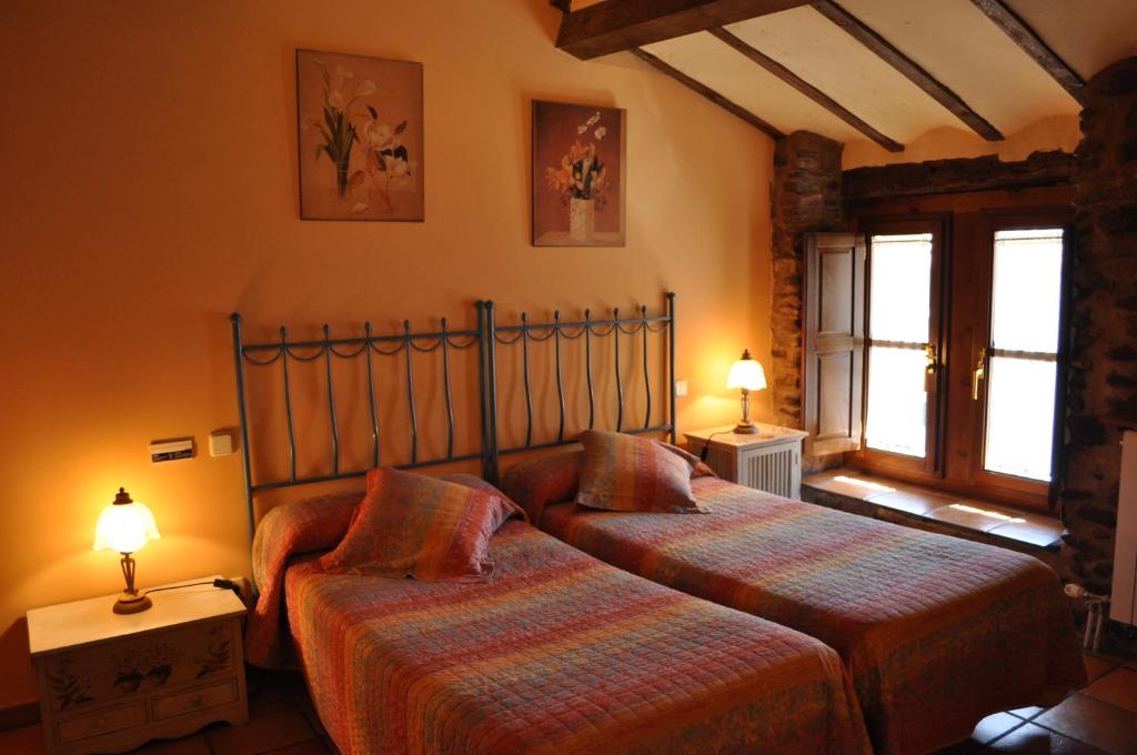 a bedroom with two beds and two lamps in it at La Cuculla in Ezcaray