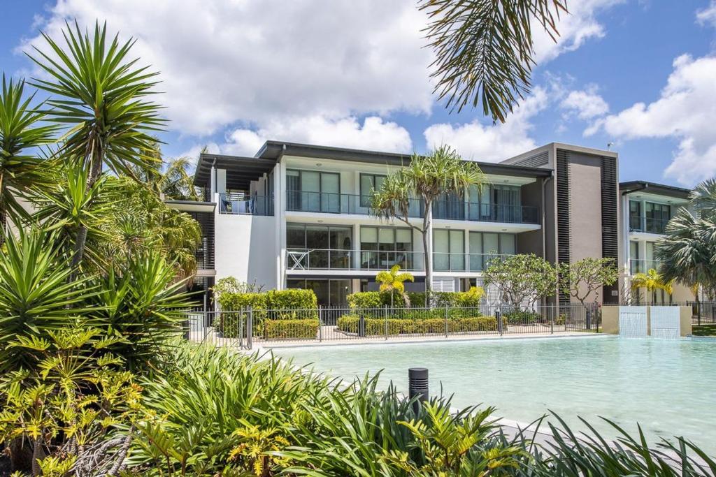 an apartment building with a swimming pool in front of it at Blue on Blue Apartment 1015 in Nelly Bay