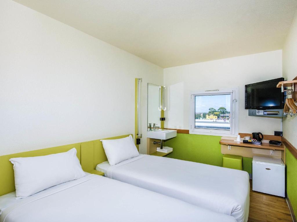 a small room with two beds and a sink at ibis Budget - Fawkner in Melbourne