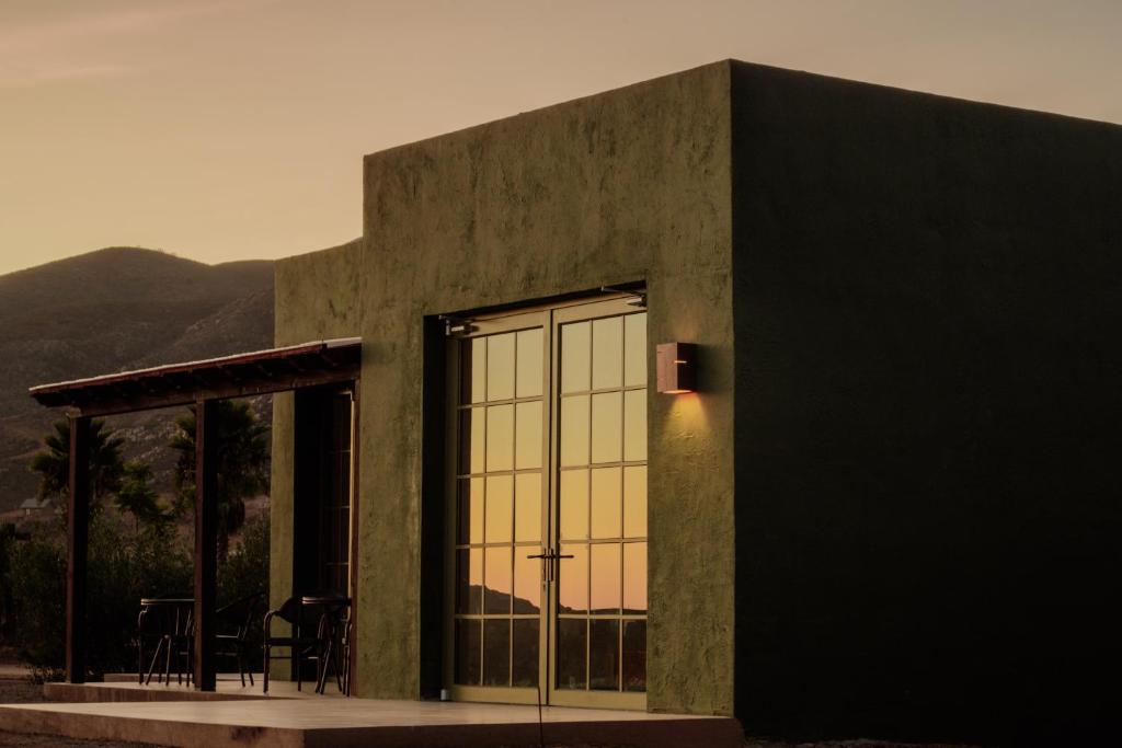 a building with a large window with a table and chairs at Nangi Hotel Boutique in Valle de Guadalupe