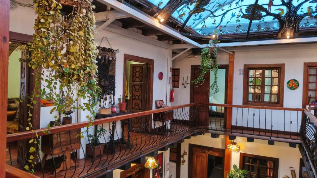 a hallway of a house with plants on the ceilings at Posada de Cantuña in Quito