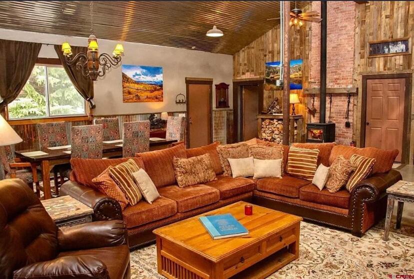 a living room with brown leather couches and a table at Couples Country Getaway in Pagosa Springs