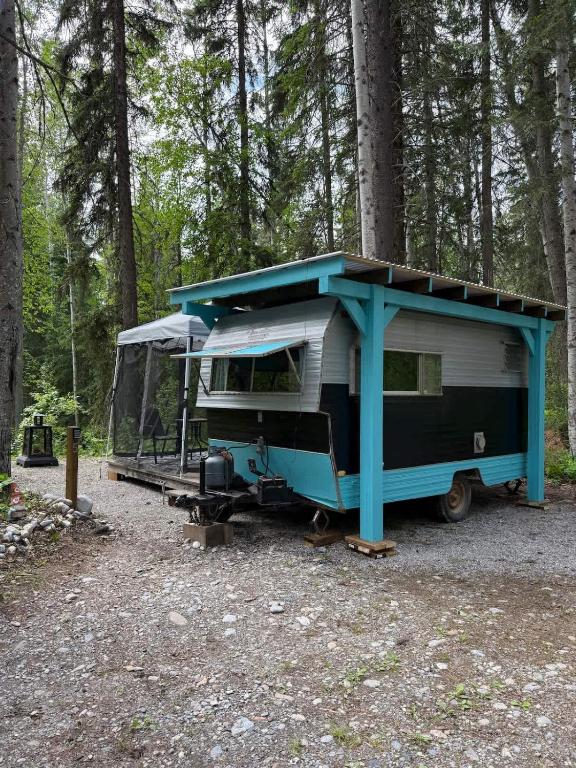 a rv parked in the middle of a forest at Cozy Vintage Camper, the Tealy Wheely in Golden