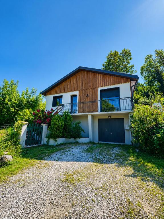 a house with a balcony and a driveway at Refuge nature de Aumontzey in Granges-Aumontzey