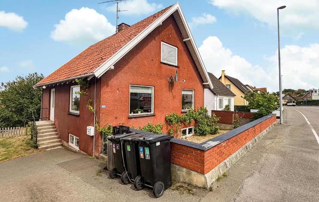 a red brick house with two trash cans in front of it at Beautiful Home In Allinge With Wifi in Allinge