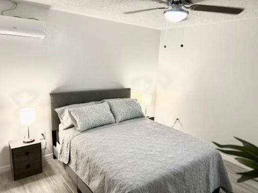 a bedroom with a bed and a ceiling fan at Brisa Marina Suites in New Port Richey