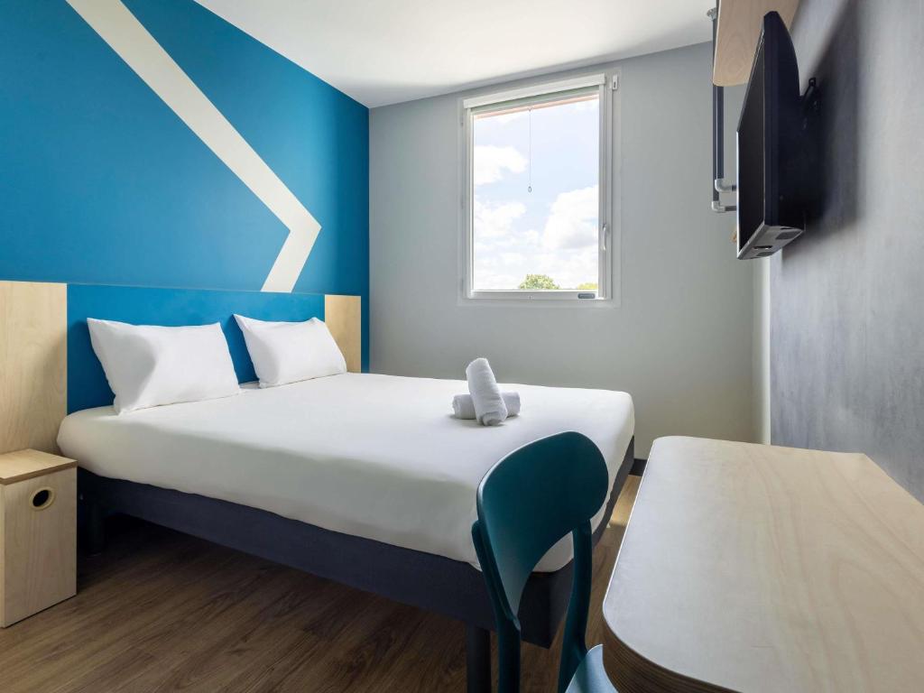 a small room with a bed and a window at ibis budget Nanterre la Defense in Nanterre