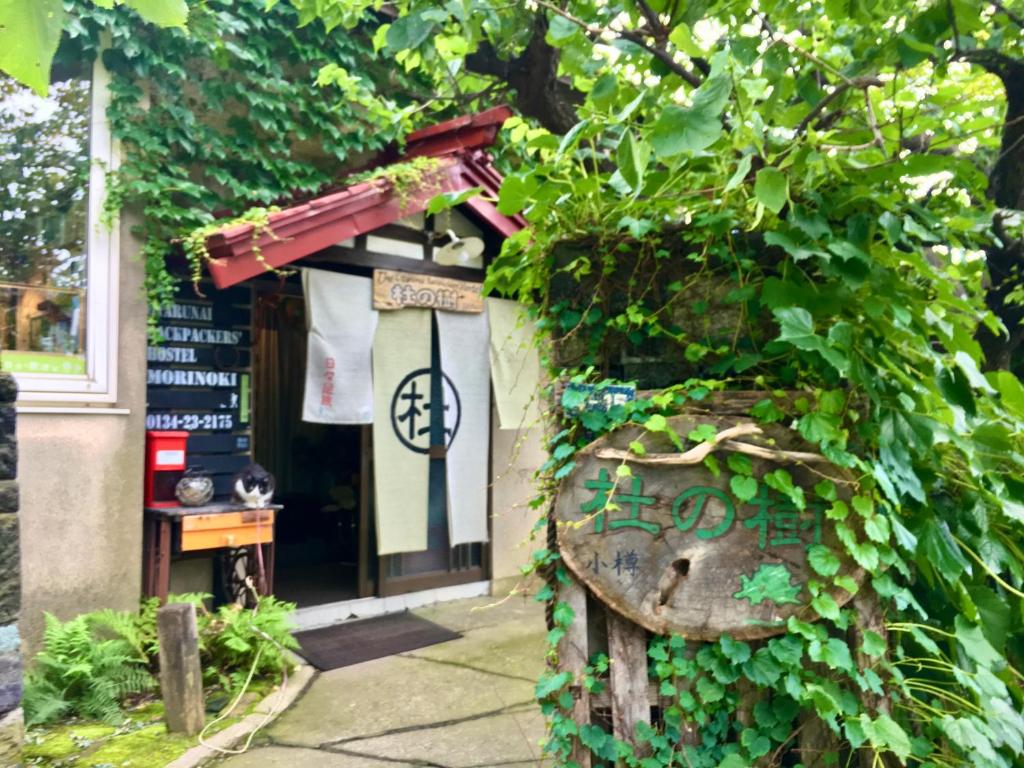 a building with a door with ivy on it at The Otaornai Backpacker's Hostel Morinoki in Otaru
