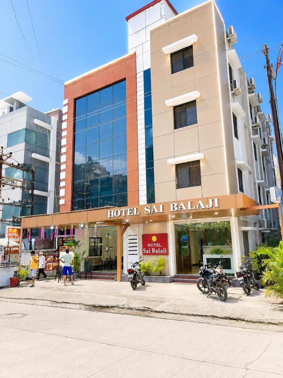 a hotel with motorcycles parked in front of a building at Hotel Sai Balaji in Shirdi