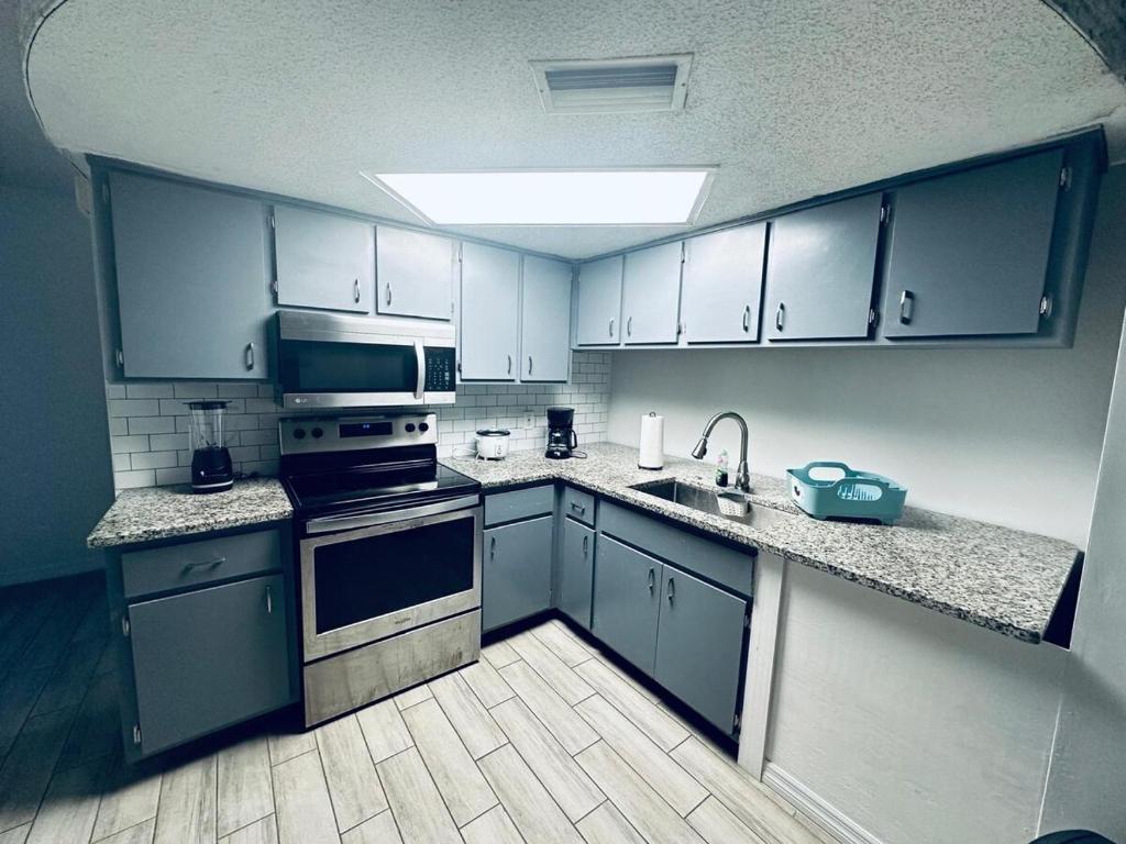 a kitchen with blue cabinets and a sink and a stove at Beautiful Brand-New studio in New Port Richey