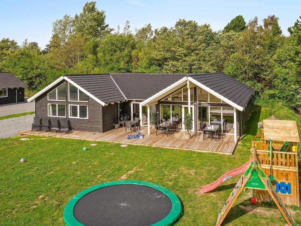 a house with a deck and a playground at 5 star holiday home in Vejby in Vejby