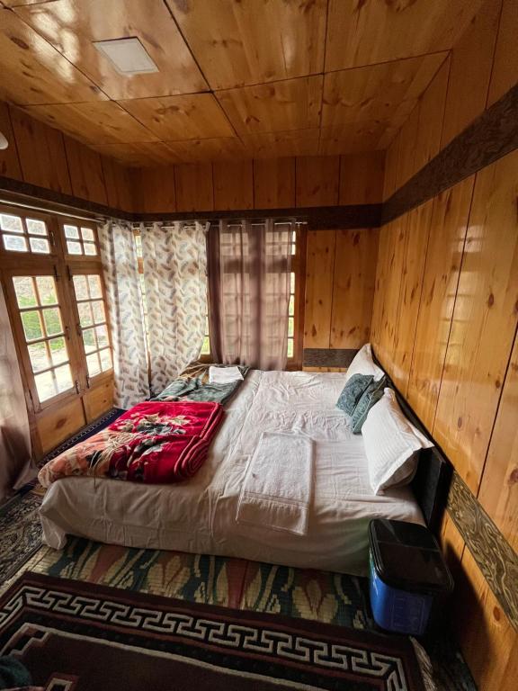a large bed in a room with wooden walls at Dosho pa in Dah