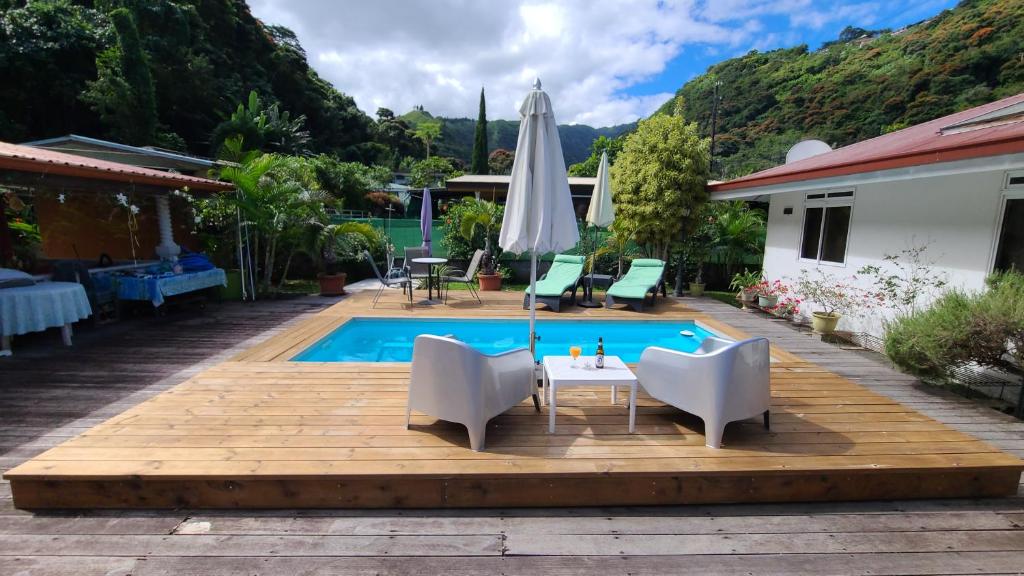 a patio with a table and chairs next to a pool at Sweet little house - private pool in Punaauia