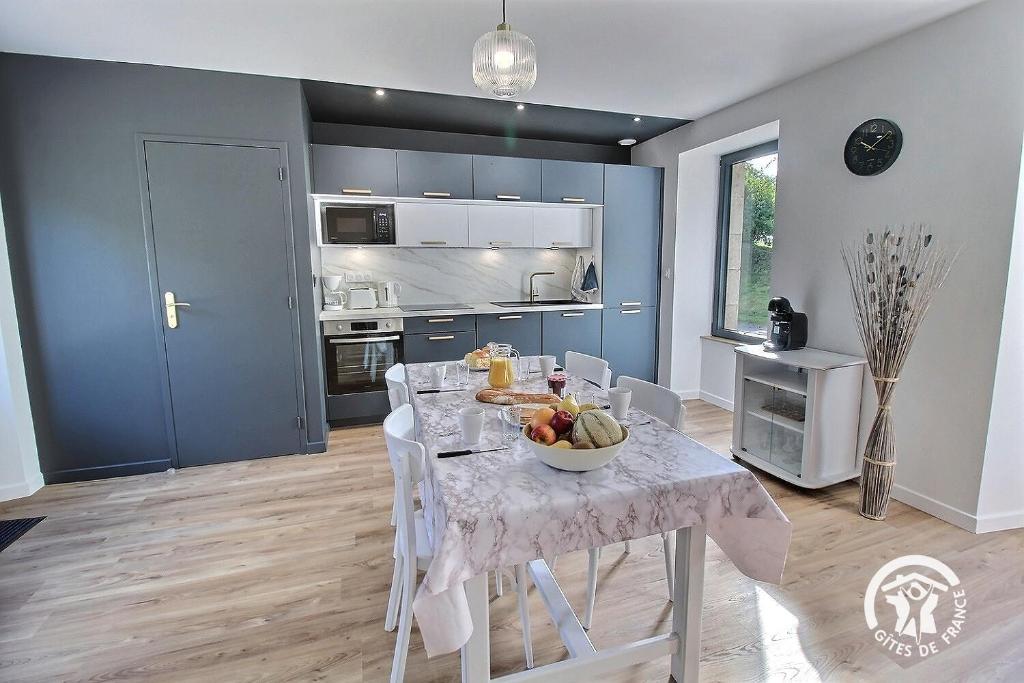 a kitchen with a table with a bowl of fruit on it at Ty prad in Lanvellec