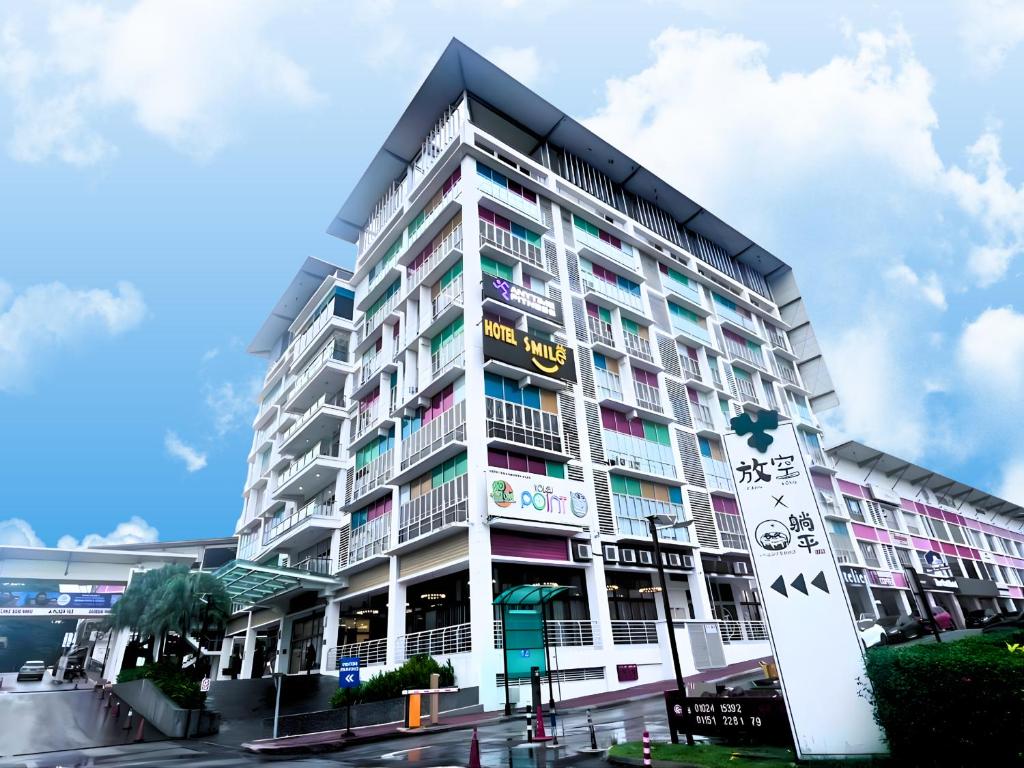 a tall white building with a lot of windows at Smile Hotel Damansara Tropical in Petaling Jaya