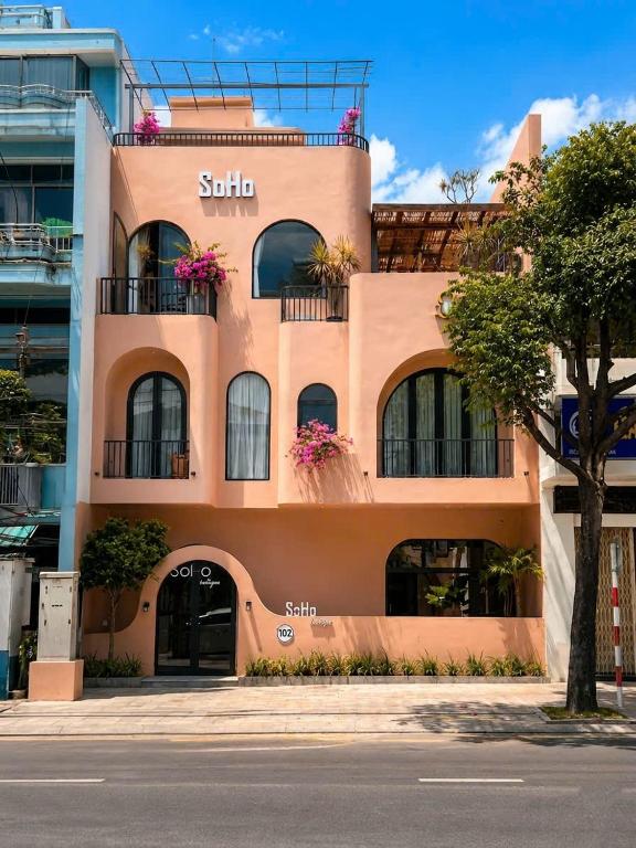 a tan building with flowers on the balconies at Soho Boutique in Quảng Ngãi